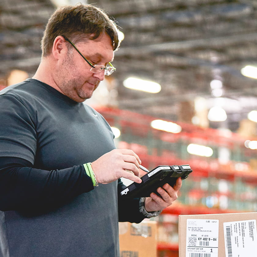 Warehouse worker reading from a tablet
